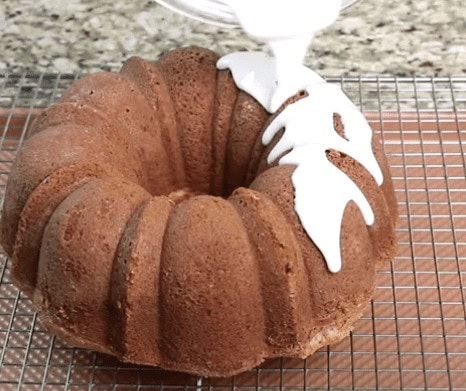 drizzling the icing over the cake